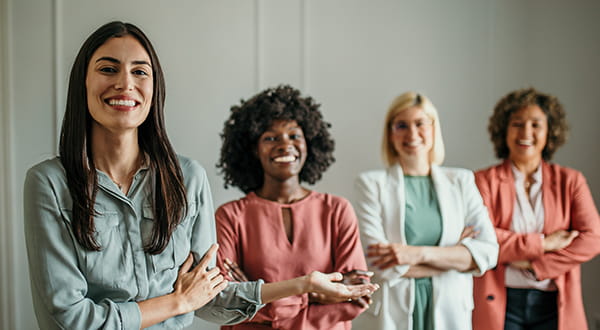 Agevolazione assunzioni donne | Immagine di quattro donne di origine diversificata che sorridono