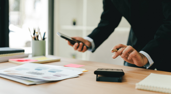 Calcolo della detrazione per lavoro dipendente | Dettagli della mano di un lavoratore che effettua il calcolo delle detrazioni