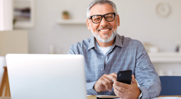 Programma GOL | Immagine di un lavoratore senior sorridente al pc nella sua casa