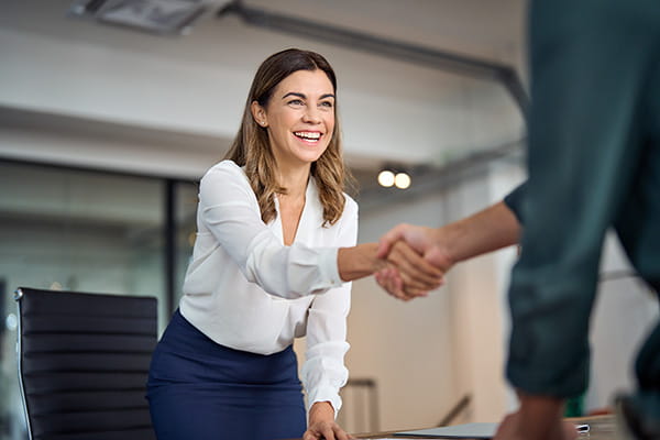 Contratto di apprendistato | Immagine di donna che sorride e stringe la mano ad un uomo