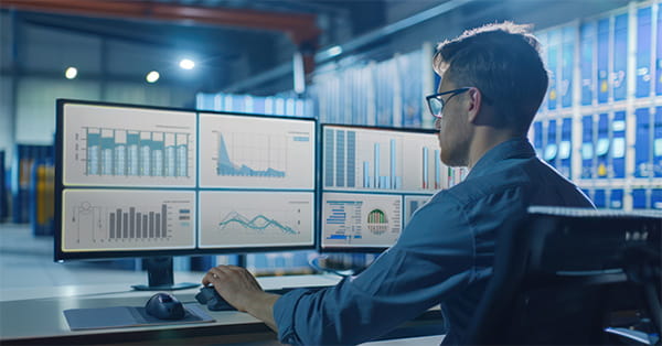 Supply chain management | Immagine che mostra un uomo al computer mentre osserva dei grafici
